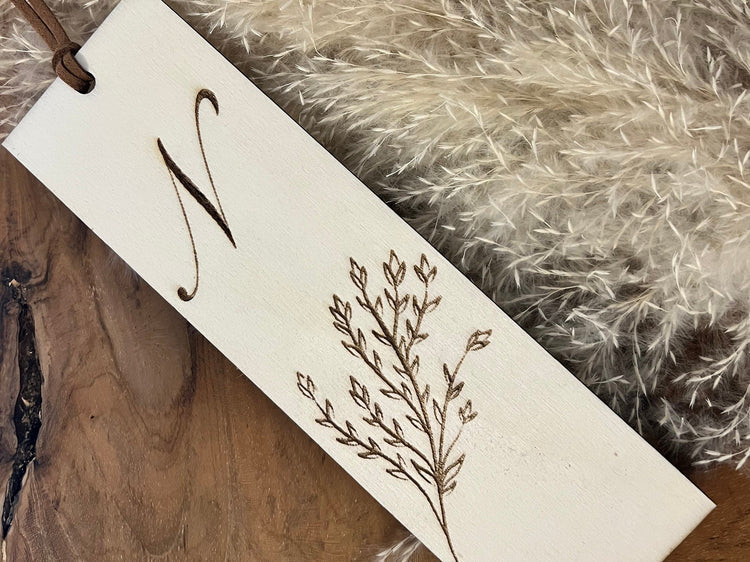 Lesezeichen aus Holz personalisiert mit dem Initialen und Blumenmuster graviert.