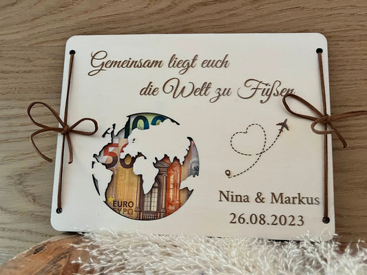 Hochzeitsgeschenk: Geldgeschenk zur Hochzeit für Flitterwochen. Gravierte Holzplatten mit der Aufschrift: Gemeinsam liegt euch die Welt zu Füßen. Dabei ist eine Wetkugel ausgeschnitten wo das Geld durchscheint.