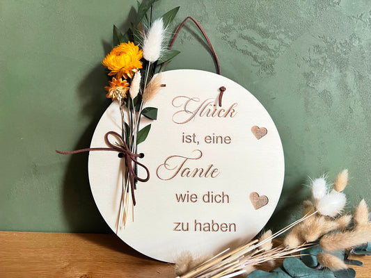 Graviertes Holzschild mit dem Spruch: Glück ist eine Tante wie dich zu haben. Dabei kann man dieses Geschenk auch  für die Patentante erstellen. Dekoriert mit Trockenblumen wird dieses Geschenk zu einer wunderschönen und persönlichen Dekoration.