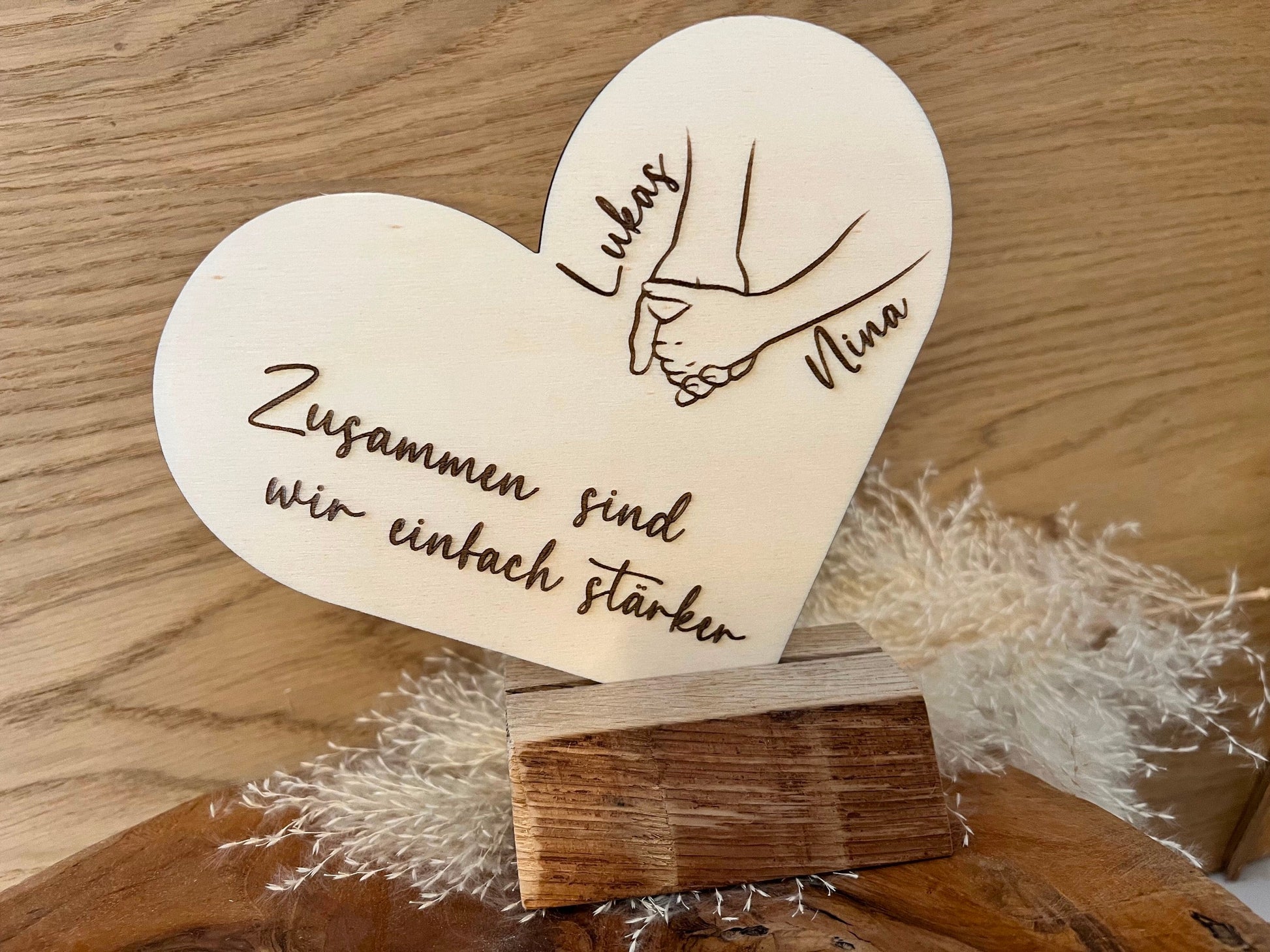 Personalisiertes Herz aus Holz mit den Wunschnamen und dem Spruch: Zusammen sind wir einfach stärker. Dabei ist ein Holzständer aus Eichenholz wo das Herz hineingesteckt werden kann.