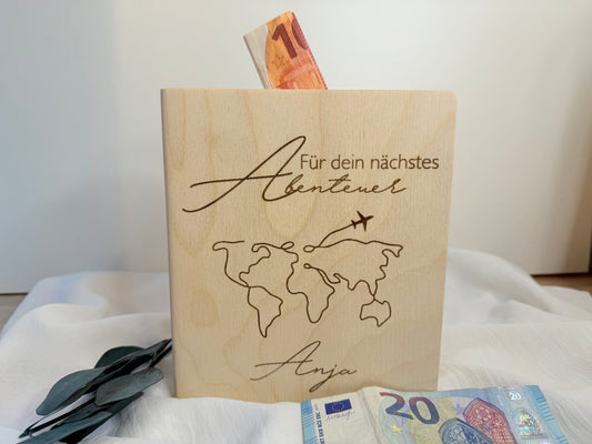 Geschenkidee für Reisen. Spardose aus Holz in Buchform graviert mit der Aufschrift: Für dein nächstes Abenteuer personalisiert mit Namen.